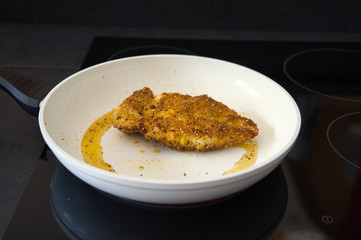 Hähnchenbrust, Schnitzel beim anbraten in einer weißen Pfanne