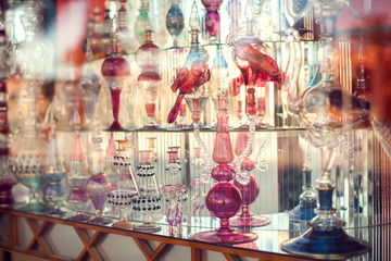 Fototapeta na wymiar A lot of beautiful empty arabic style glass bottles for perfume in the shop behind the glass
