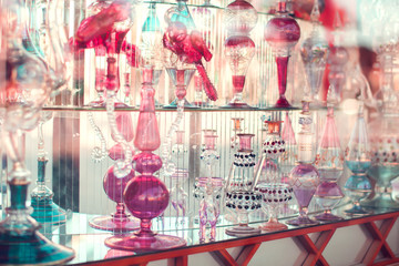 A lot of beautiful empty arabic style glass bottles for perfume in the shop behind the glass