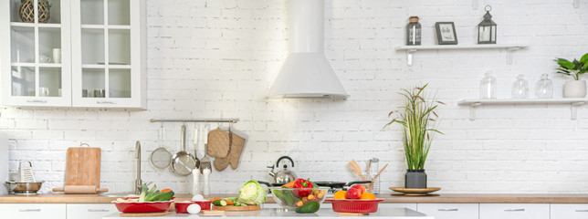 Modern stylish kitchen interior with vegetables and fruits on the table .