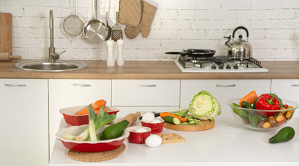 Modern stylish kitchen interior with vegetables and fruits on the table .