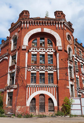 Facade of an old abandoned red brick house in art Nouveau style, late 19th century. One of the buildings in the historical architectural and industrial complex 