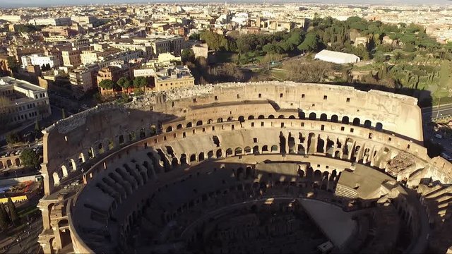 Aerial drone view video of iconic ancient Arena of Colosseum, also known as the Flavian amphitheatre in the heart of Rome. Cityscape aerial view drone flying to Colosseum.