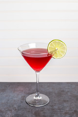 Cosmopolitan cocktail in martini glass with lime