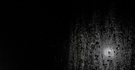 Texture of water drops on glass on a black background