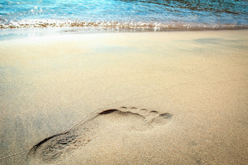 Footprints by the sea beach on nature in travel vacation background