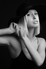 Black and white portrait blondes on black background in a hat and Tank Top With Thin Straps