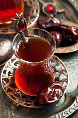 Turkish tea in traditional glass with sweet dates