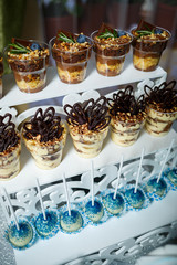 Beautifully decorated sweet buffet table on which cakes, muffins, marshmallows, pecans. Dessert table for a party, goodies for the wedding. Close up. Candy bar. A buffet for a wedding