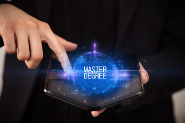 Young man holding a foldable smartphone with MASTER DEGREE inscription, educational concept