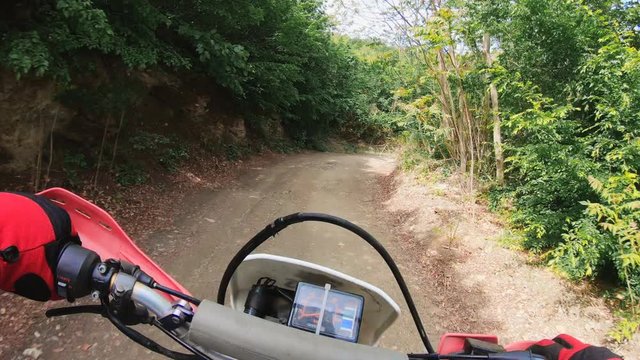 POV of a man on a bike drives enduro cross on rural road