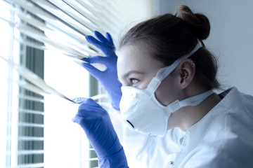 young doctor with ffp3 protective mask at the window