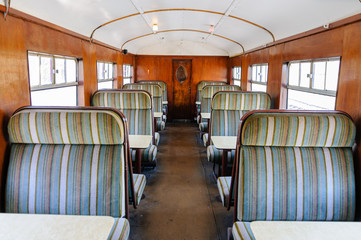 Inside a carriage of an old fashioned train.