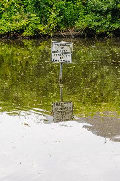 Sign in a lake saying "Verboden te vissen" and "Verboden te zwemmen" (fishing and swimming are forbidden)