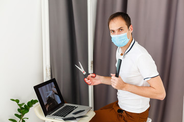 Obraz na płótnie Canvas Portrait of a man makes a haircut for himself during quarantine
