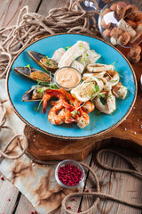 Seafood-mussels and shrimps, fish, beer snacks on the background of a wooden table.