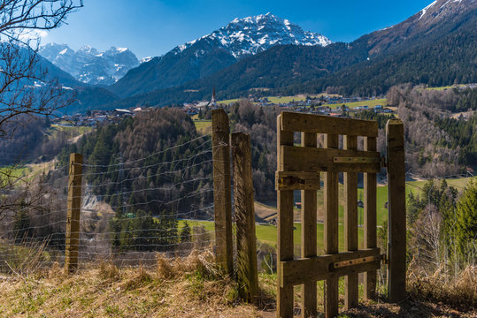 H&ouml;lzernes Gatter auf einer Wiese im Stubaital mit Blick auf die Berge