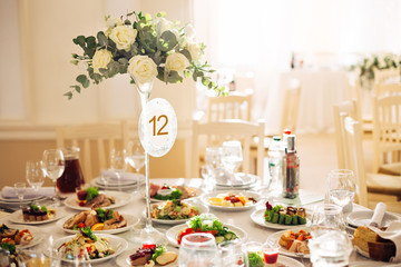 festive table with dishes and drinks decorated with a tall vase