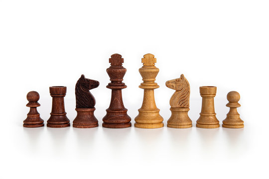 Wooden chess pieces aligned on a white background. Picture taken in studio with lightbox.