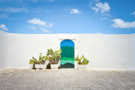 Fototapeta Ostuni white town street view. The house with the blue door. Brindisi, Apulia (Puglia) southern Italy. Europe.