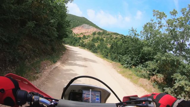 Off-road cross motorbike rides on rural mountain road
