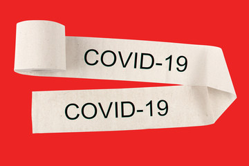 Unwound  roll of toilet paper with the inscription COVID-19 , on a red background. The concept of warning and deficit.