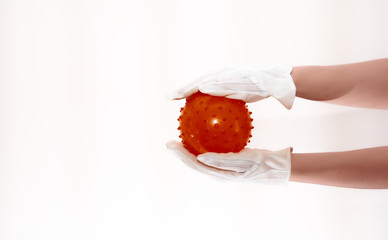 a girl’s hand in a glove holds a round ball similar to a visualization of a virus. Social hand...
