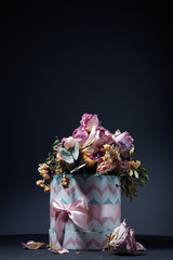 Bouquet of dried flowers in gift box on table over dark background