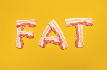Fat word made of bacon isolated on yellow