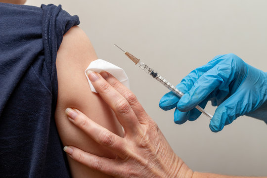 Vaccinating children in the hospital. A syringe with a vaccine in the hands of a nurse.