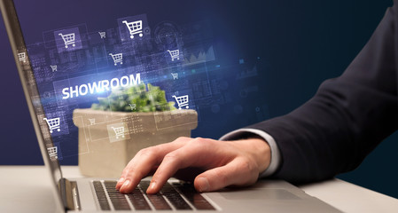 Businessman working on laptop with SHOWROOM inscription, online shopping concept