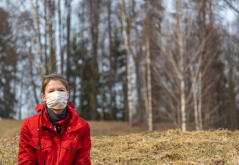 Young woman wearing medical face masks to protect themselves from coronavirus at the abandoned park during quarantine. Corona virus, covid -19, pandemic protection concept.