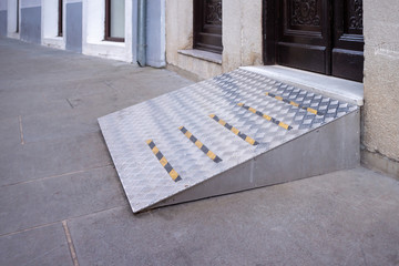 Ramp for disabled persons on wheelchair at building entrance.