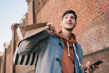 Young man using his mobile phone on the street.