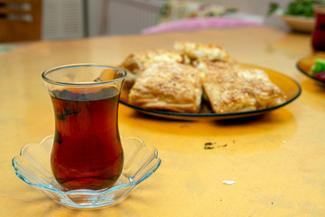 Delicious homemade burrito slices and tea , ready to eat. Turkish borek slices.
