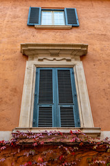 Rome, Italy. Closed windows and wooden shutters from outside homes/ houses/ apartments/ residences in the urban European city. Style details of traditional vintage architectural design.