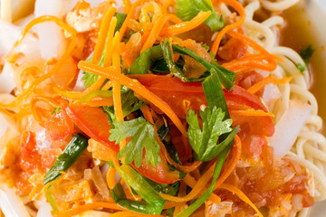 Delicious asian food in take-out box. Close up on noodles with fried vegetables and seafood then stirred soy sauce. Food delivery service.