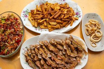 Fried fish, squid, chips and vegetable salad.