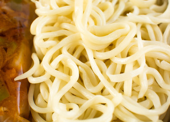 Delicious asian food in take-out box. Close up on noodles with fried vegetables and seafood then stirred soy sauce. Food delivery service.