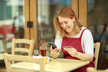 young woman ordering online at a coffeeshop
