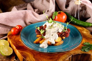 roast beef with potatoes and sauce in a plate