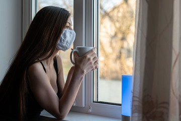 COVID-19 Pandemic Coronavirus Woman home isolation auto quarantine wearing face mask protective for...