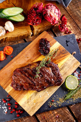 rib eye steak with margarine on a cutting Board