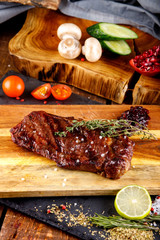 rib eye steak with margarine on a cutting Board