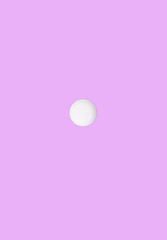 Round medical pill on a pink background. Flat lay. Medical pill concept.