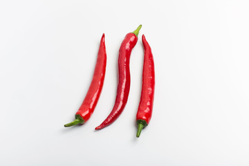 Juicy red hot chili peppers on a white background, folded in a row