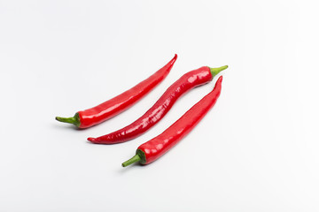 Juicy red hot chili peppers on a white background, folded in a row