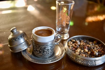 Turkish coffee served within specially designed metal cup with engravings