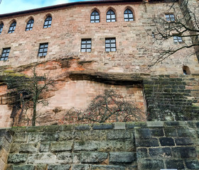 Brick and stone walls of an old building or military fortress, previously surrounded by a moat, covered with moss and painted with green silt. History, time and culture mourned in architecture.