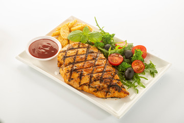 Italian style marinated chicken breast with fresh salads and tomato catchup on a white rectangle plate